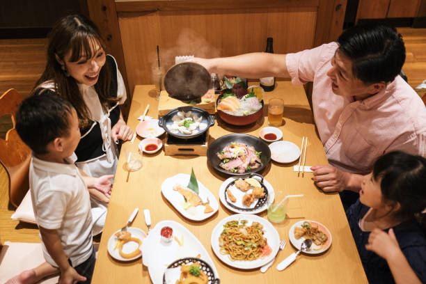 アジアの家族が日本料理店で夕食を食べる - 家族と食事 ストックフォトと画像